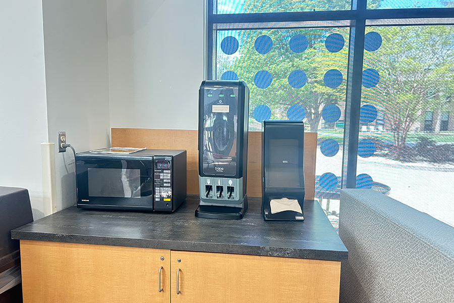 microwave on counter next to napkin and utensil dispenser