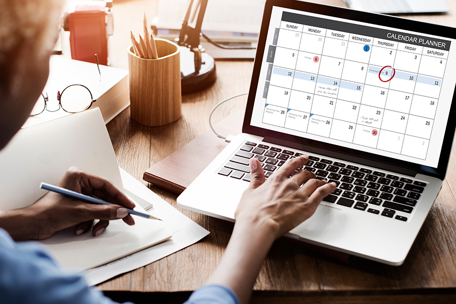 woman looking at a calendar on her laptop.