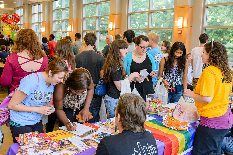 students at student fair with colorful balloons and signs