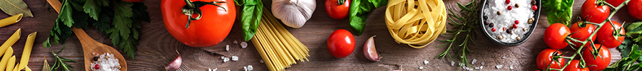 Top view of fresh cooking ingredients including tomatoes, garlic, herbs, pasta, and spices arranged on a wooden surface Top view of fresh cooking ingredients including tomatoes, garlic, herbs, pasta, and spices arranged on a wooden surface